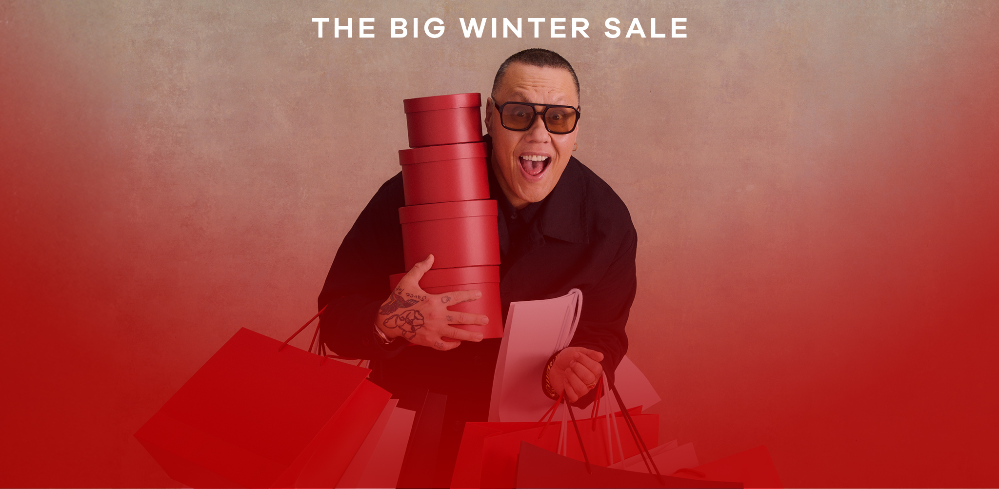 The big winter sale. Gok Wan holding some present boxes and bags