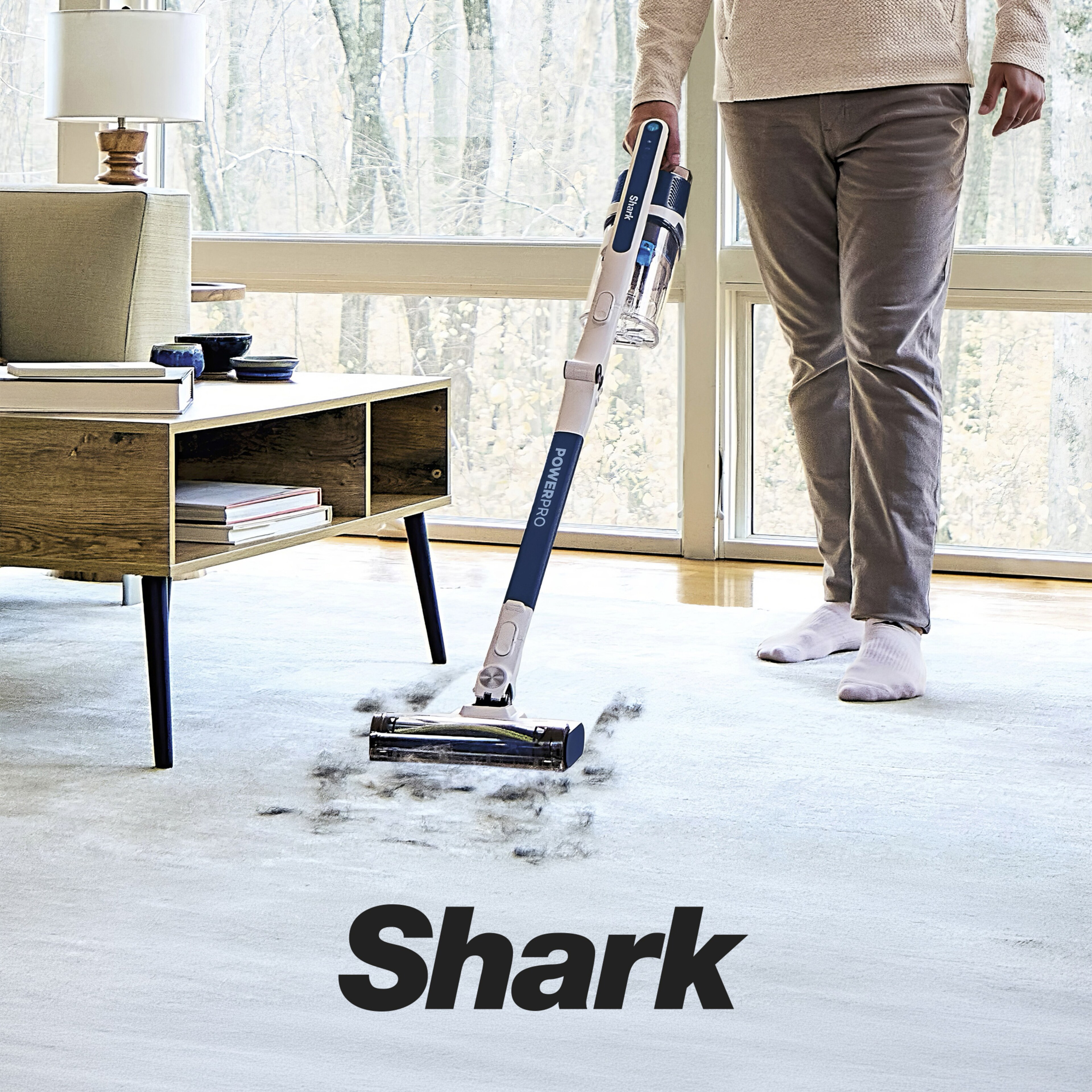 A person using a Shark cordless floor cleaning appliance.