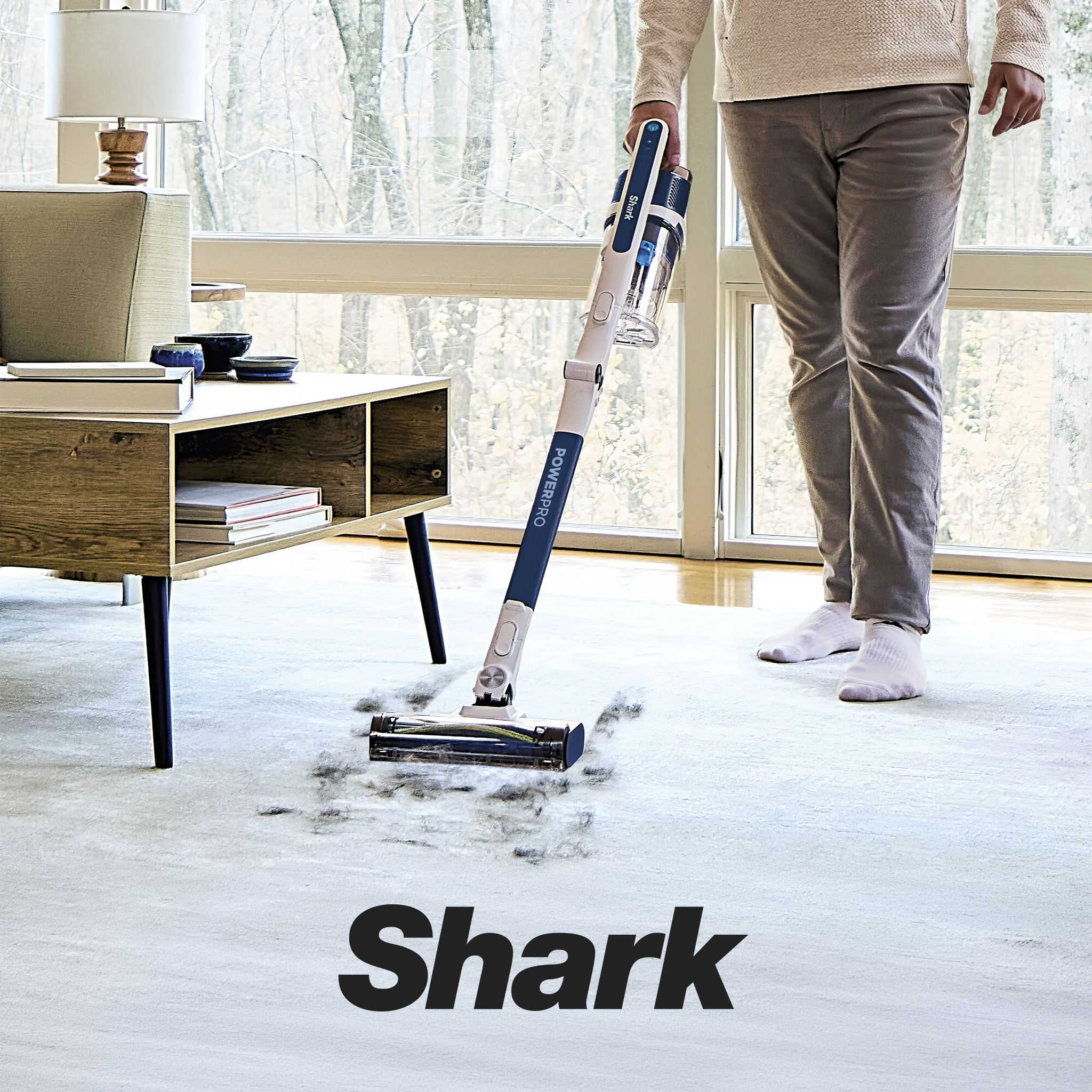 A person using a Shark cordless floor cleaning appliance.
