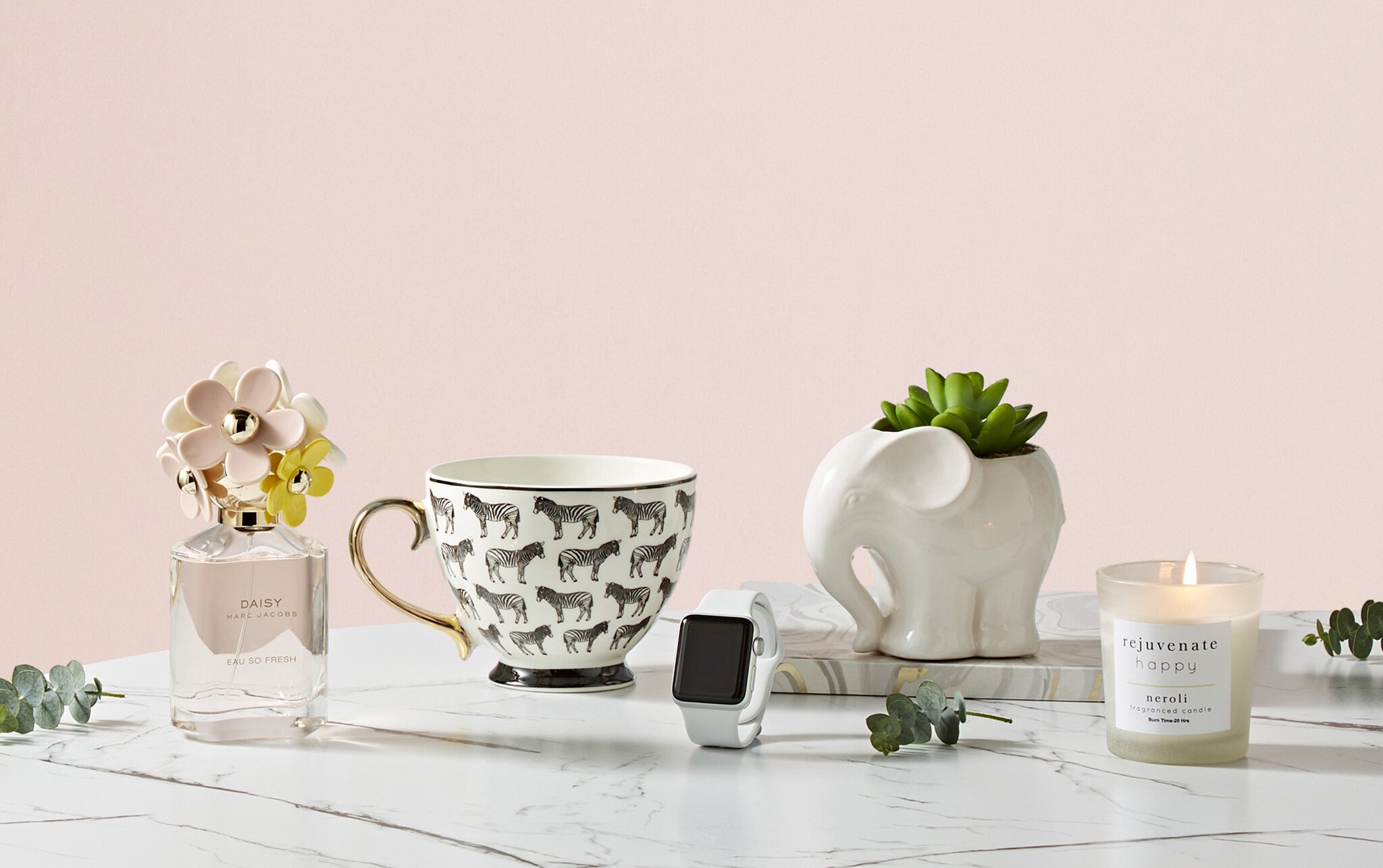 A group image of womens gifts, Daisy perfume, apple watch, a china cup and a sented candle
