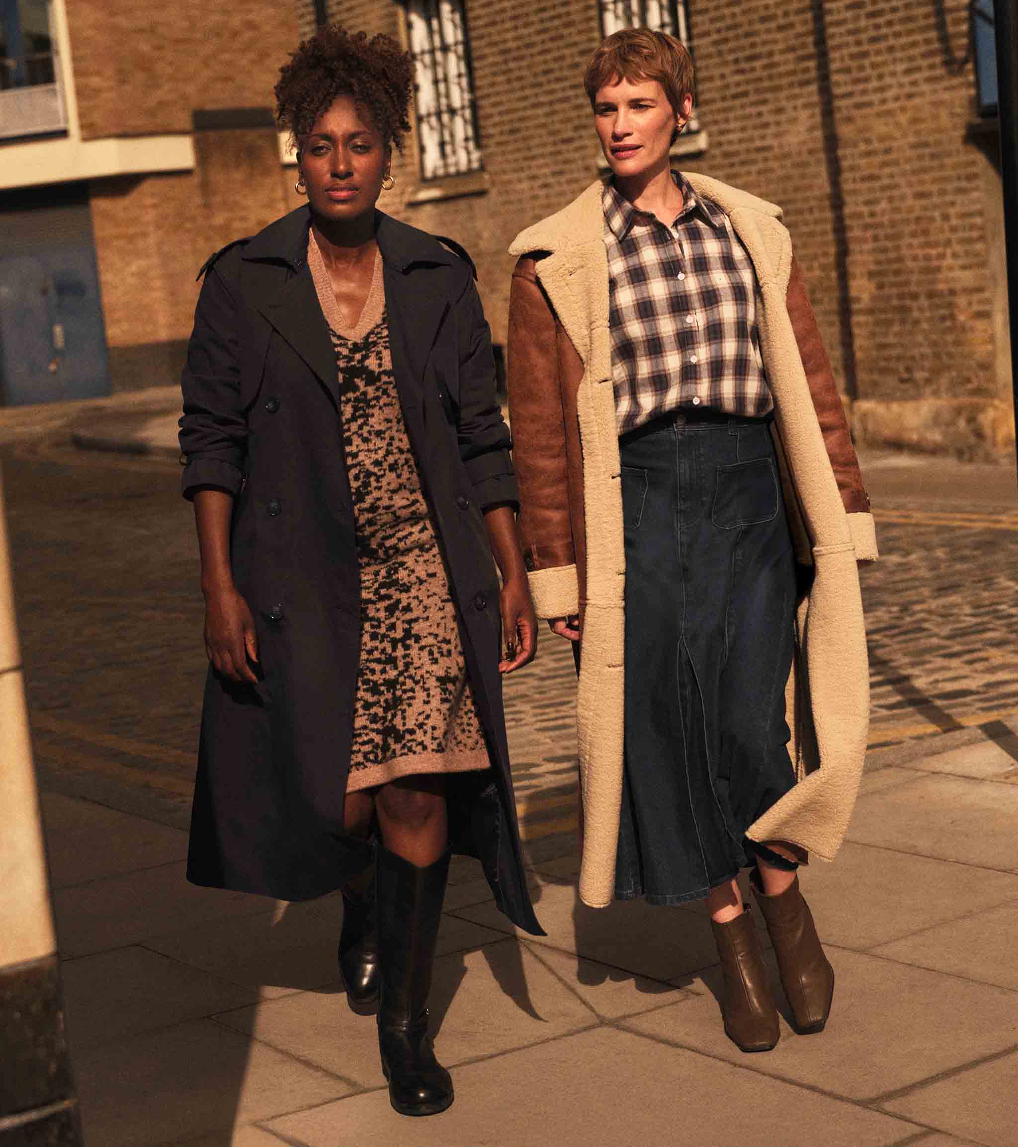 Two ladies walking on a street wearing autumnal layers.