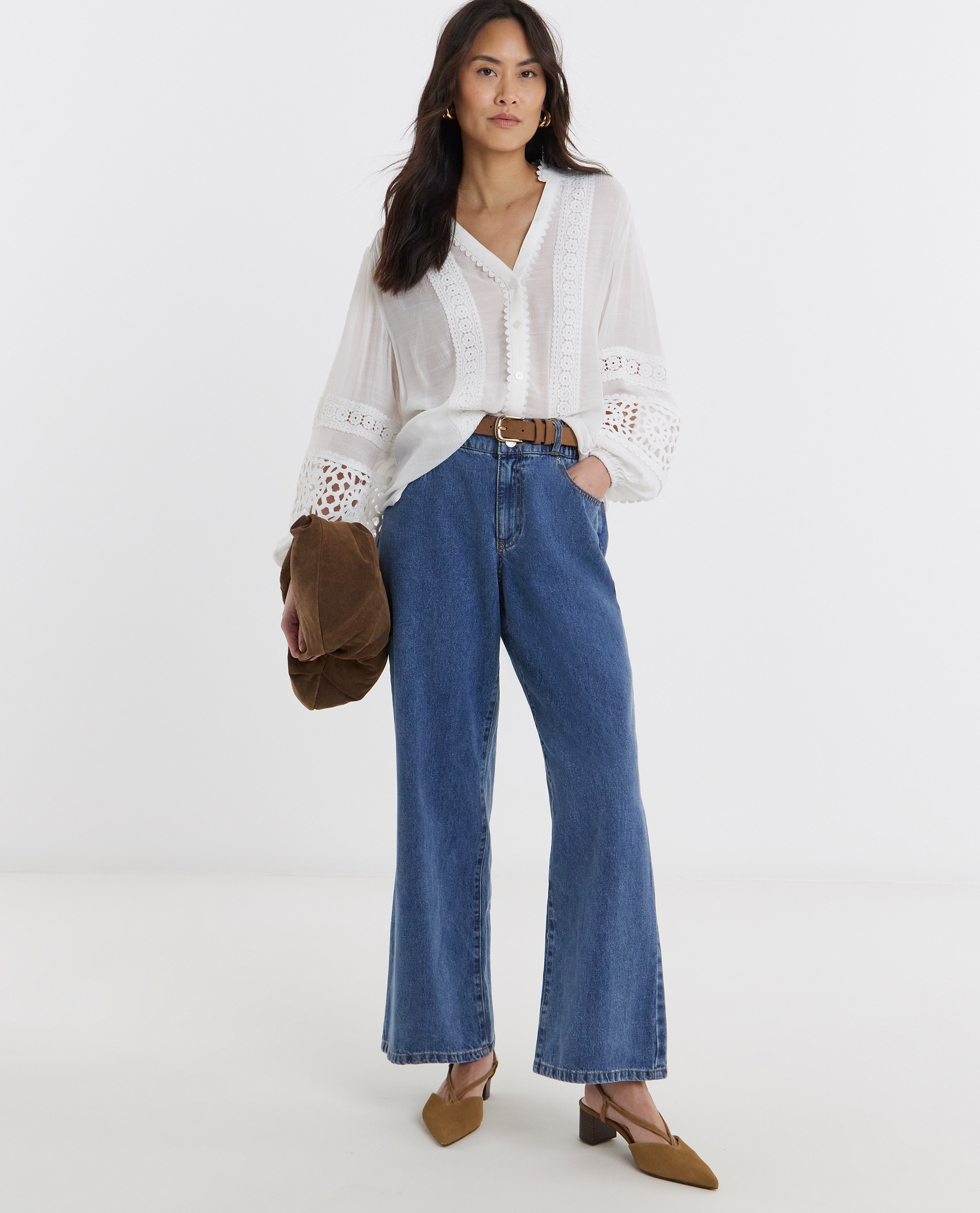 Model is wearing a lace trim button through prairie blouse with blue denim jeans
