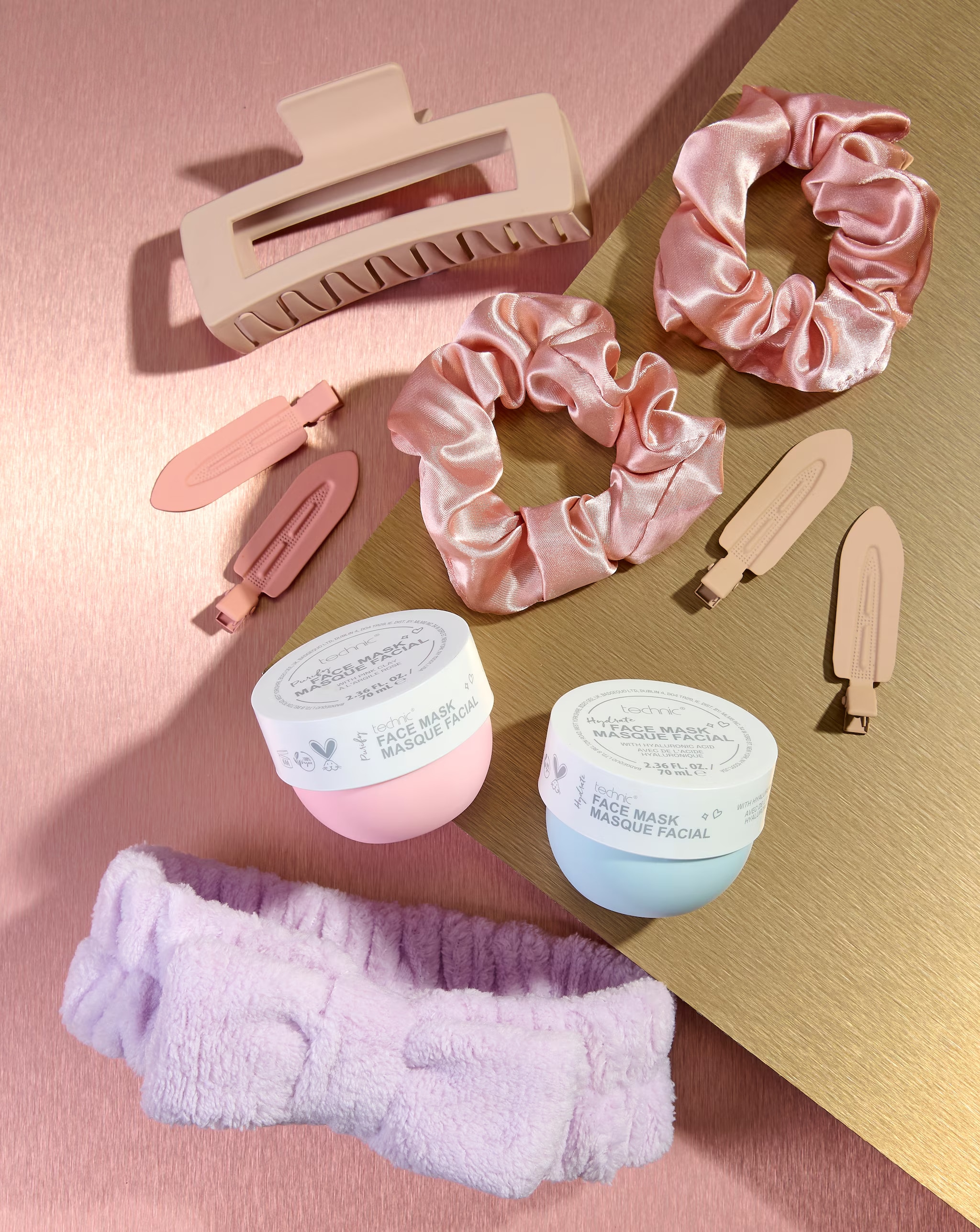 Beauty products on a glittery pink and gold surface.
