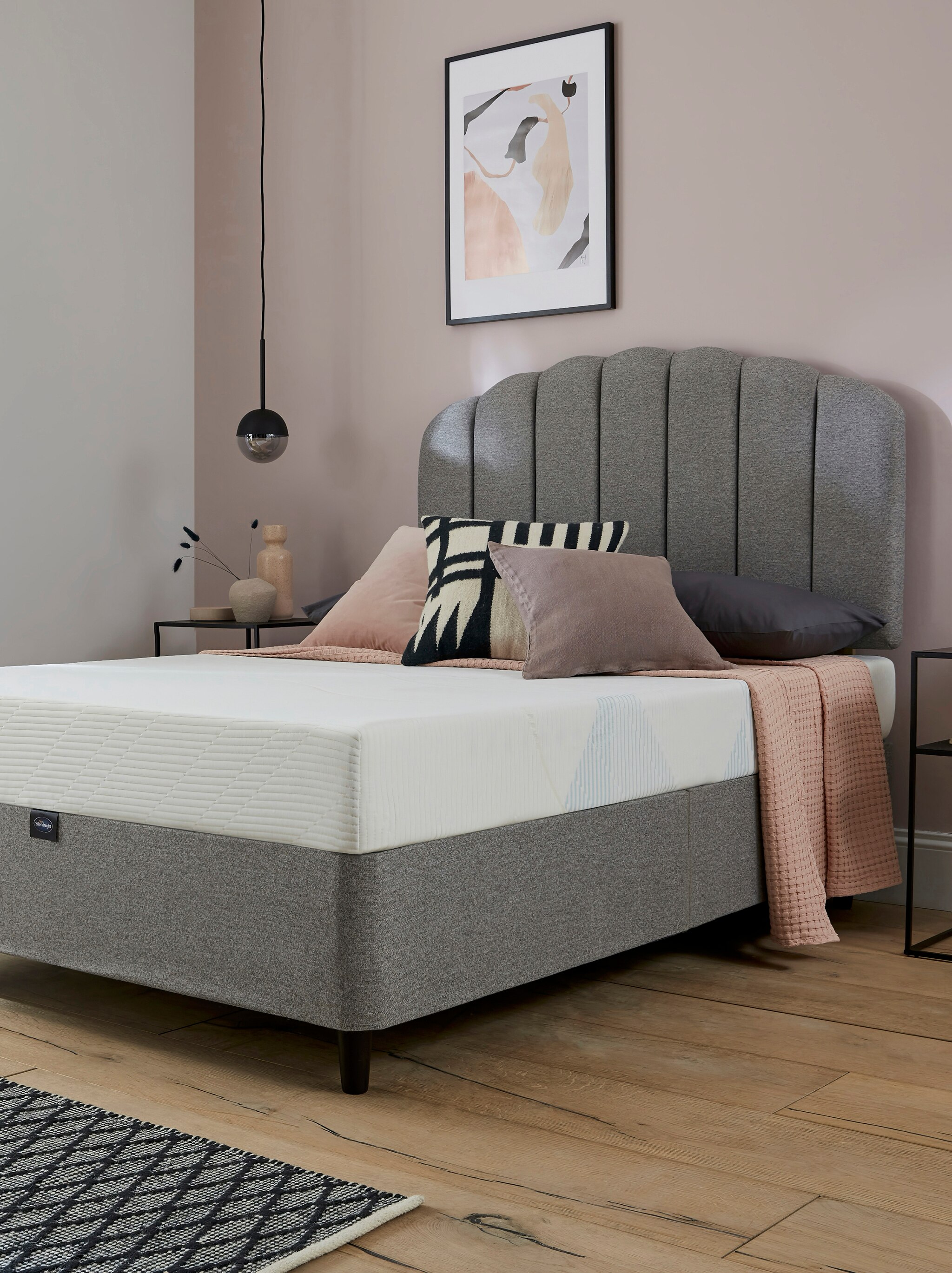 A bedroom scene with a new bed and mattress with no sheets on.