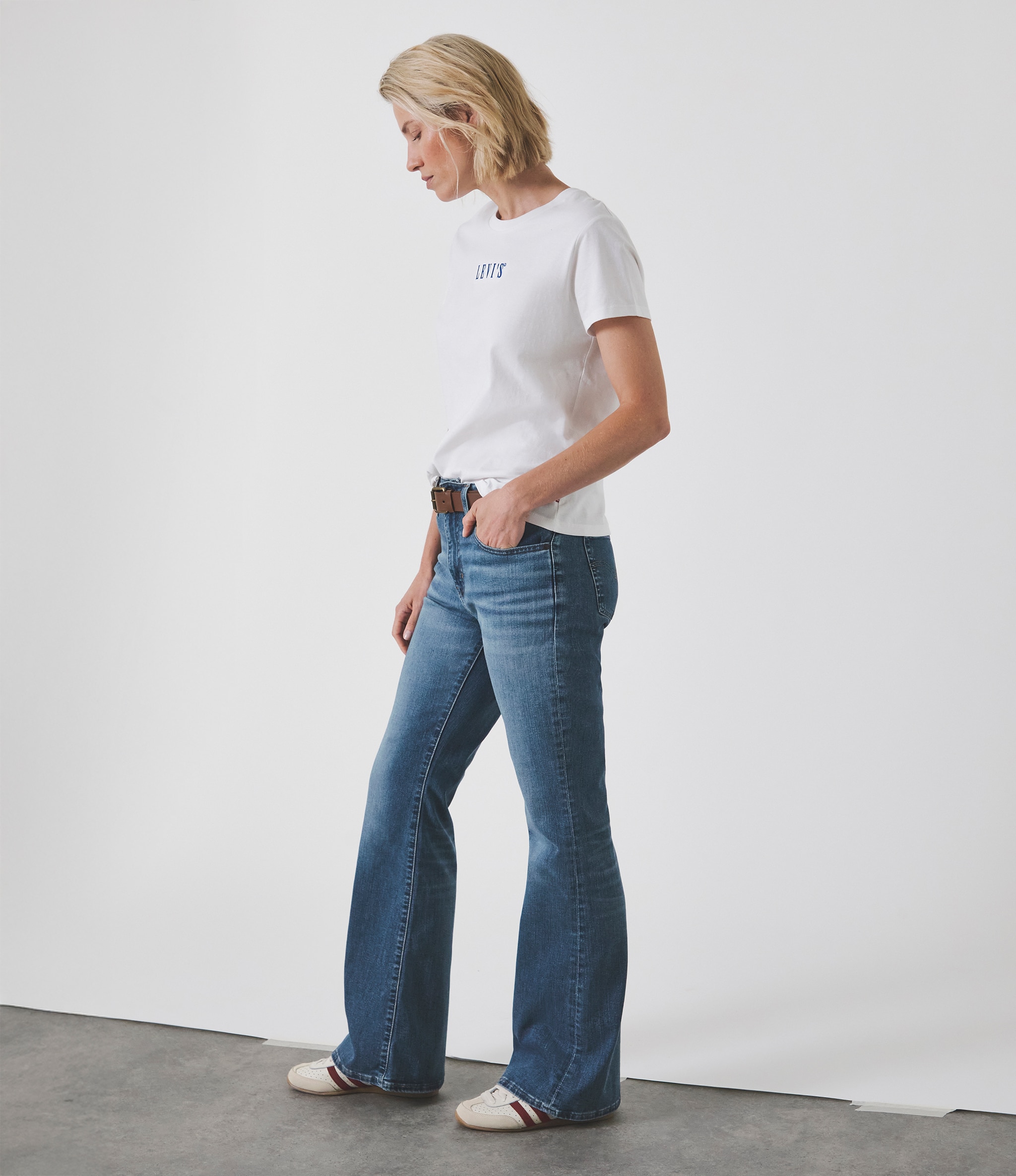 Lady stood wearing a white t-shirt with blue Levi's jeans