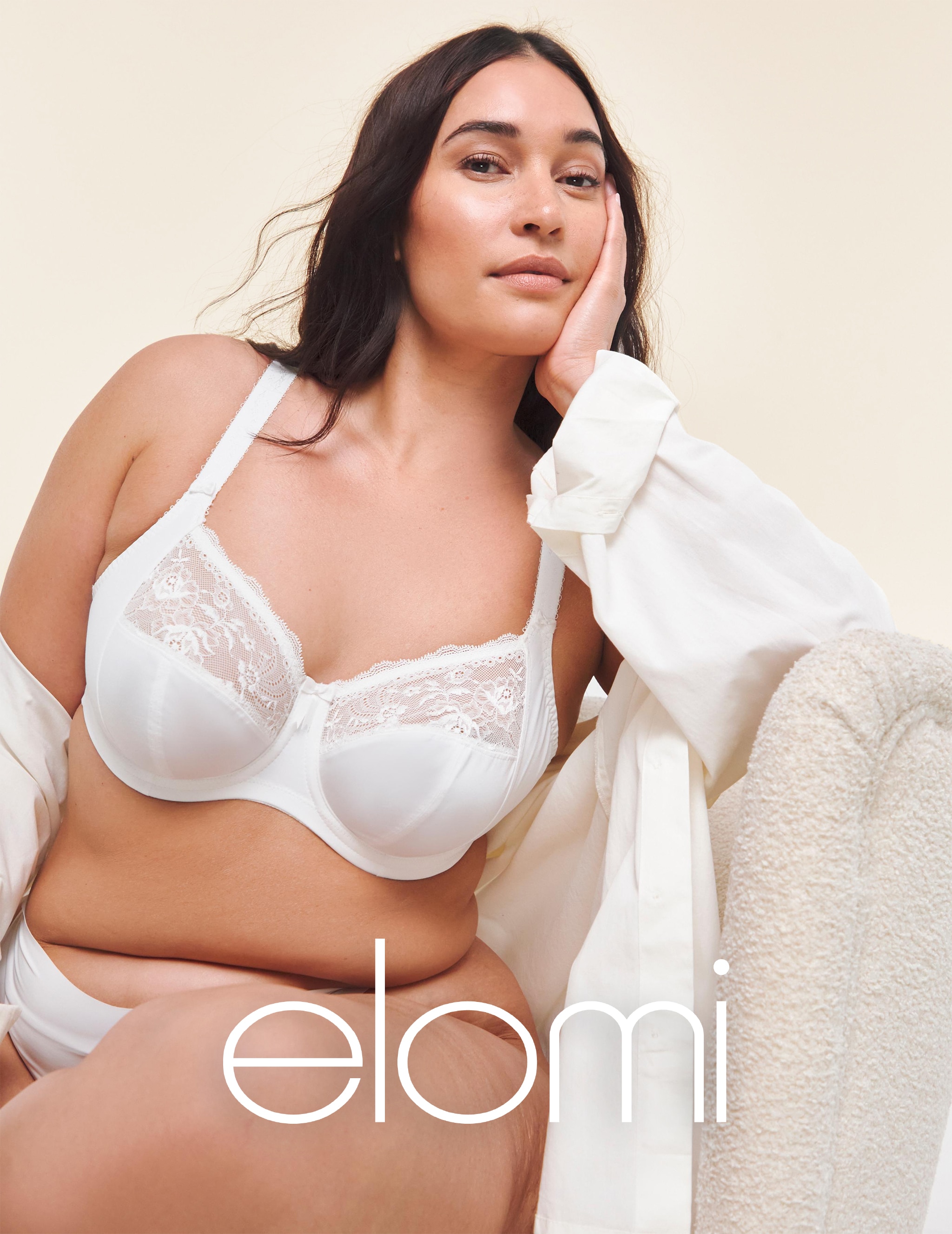 A lady sat down wearing white Elomi lingerie