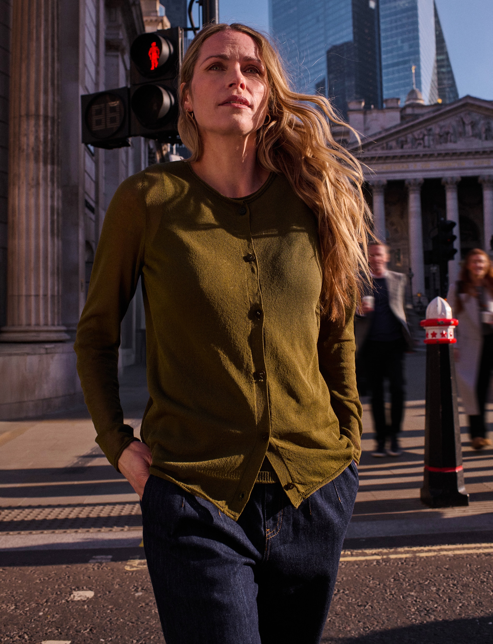 lady walking on a street wearing a green knitted top