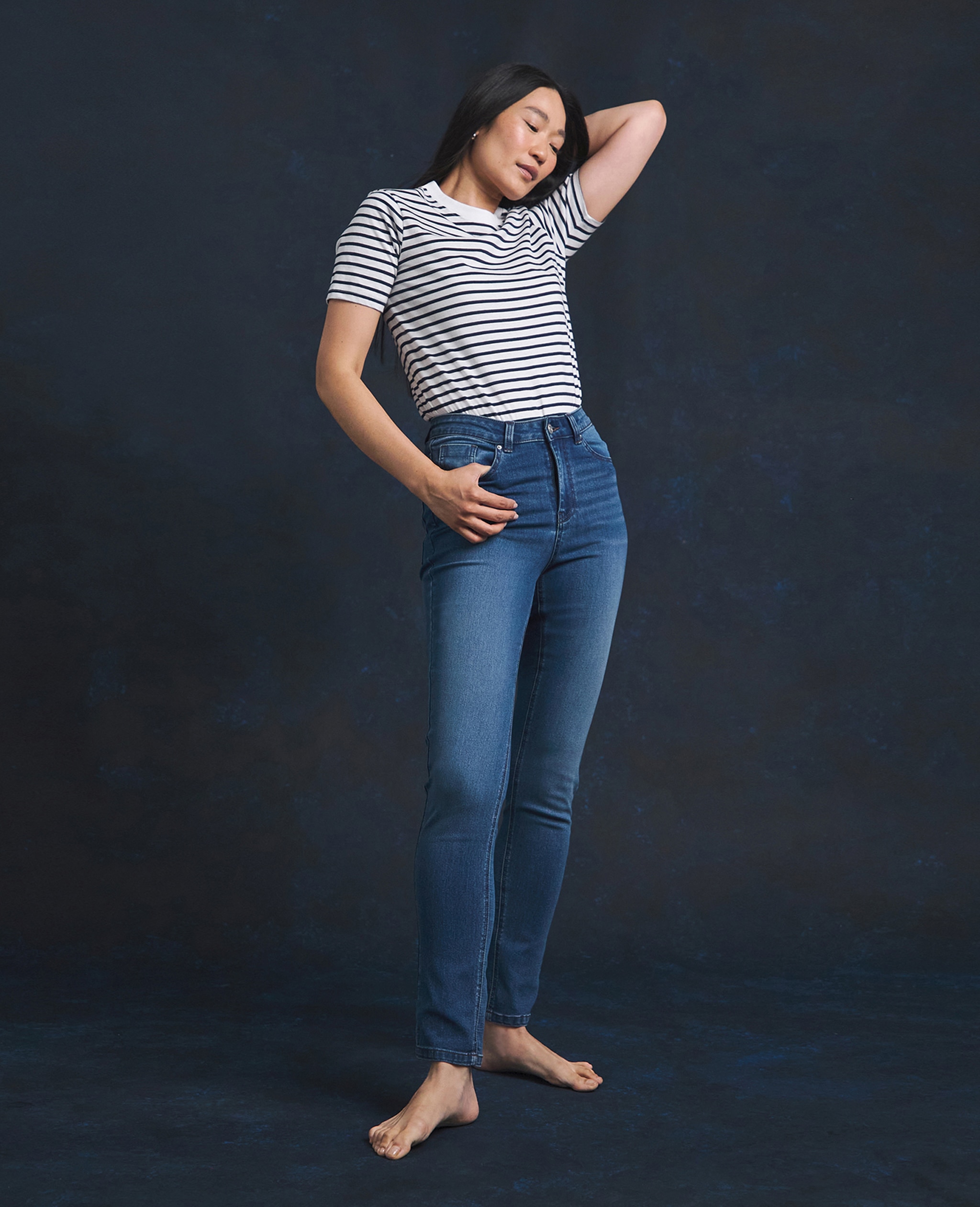 Woman wearing high waisted blue jeans and hooped t-shirt