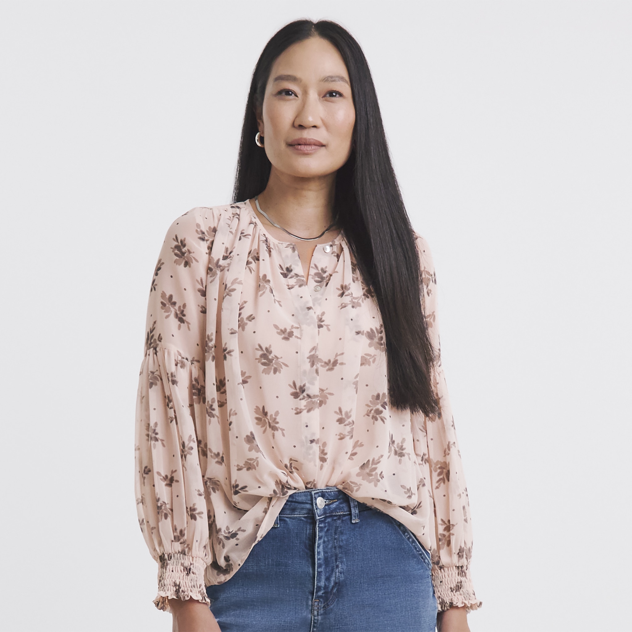 Lady wearing a floral patterned blush coloured long sleeved top.