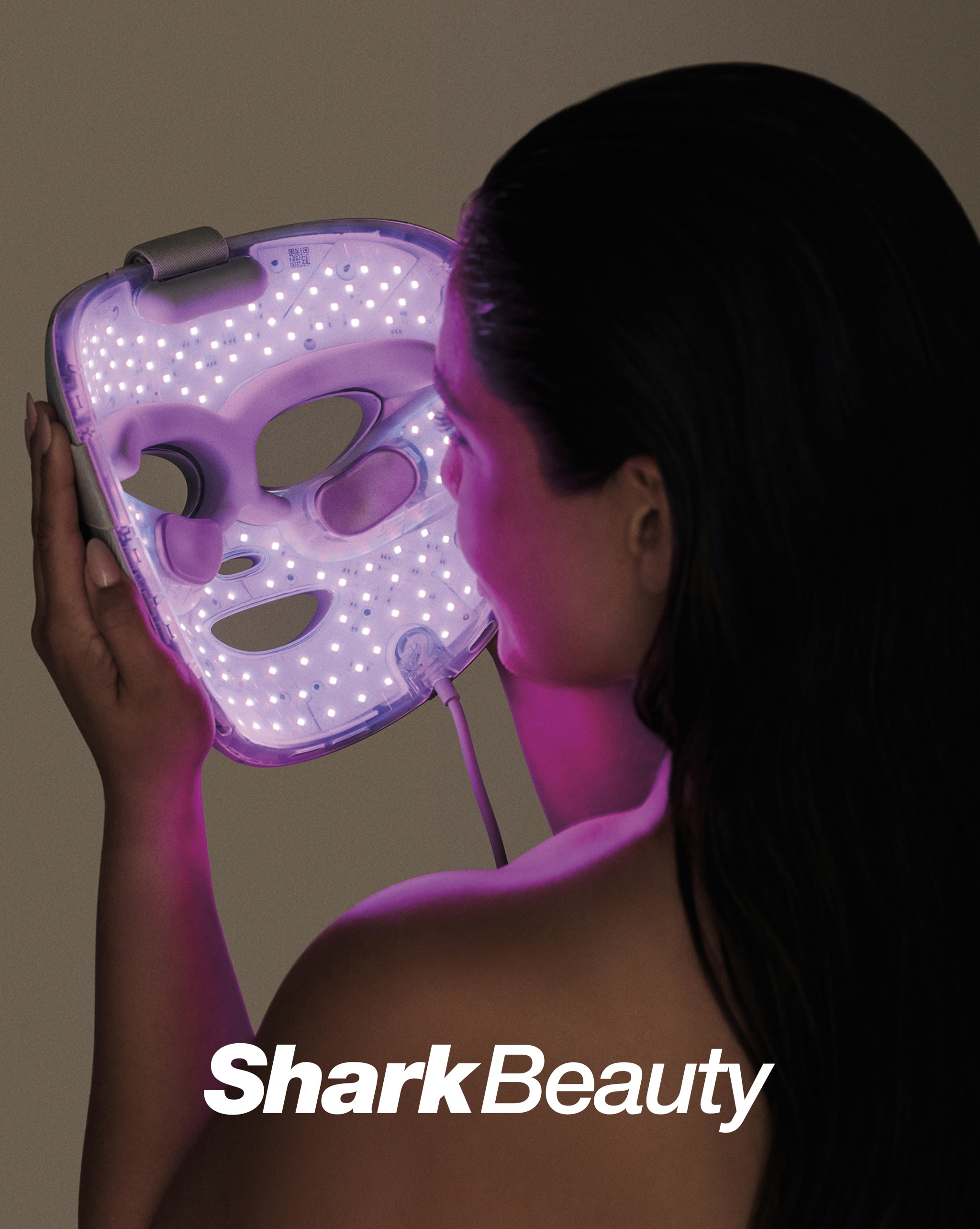 A Shark Beauty face mask lit up.