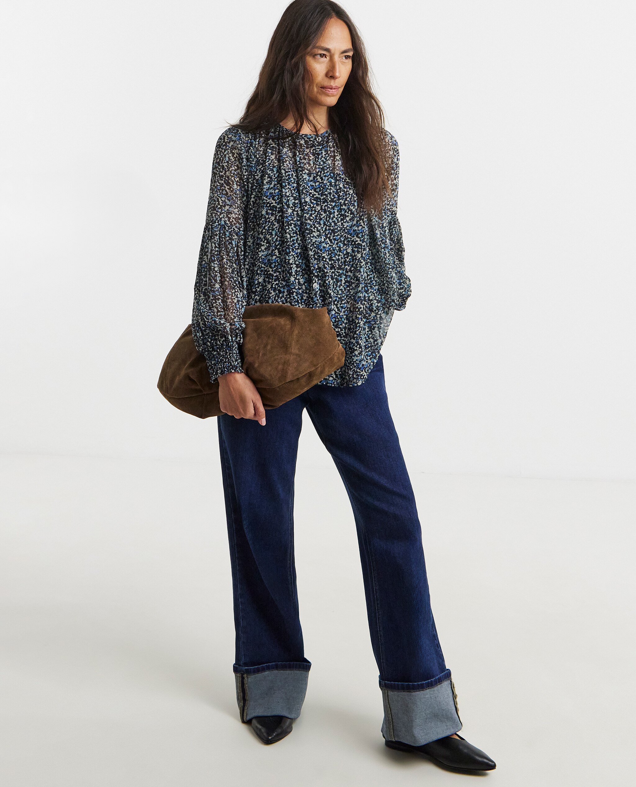 Model is wearing a blue abstract georgette collarless blouson sleeve with denim jeans and leather pointed toe flat shoes.