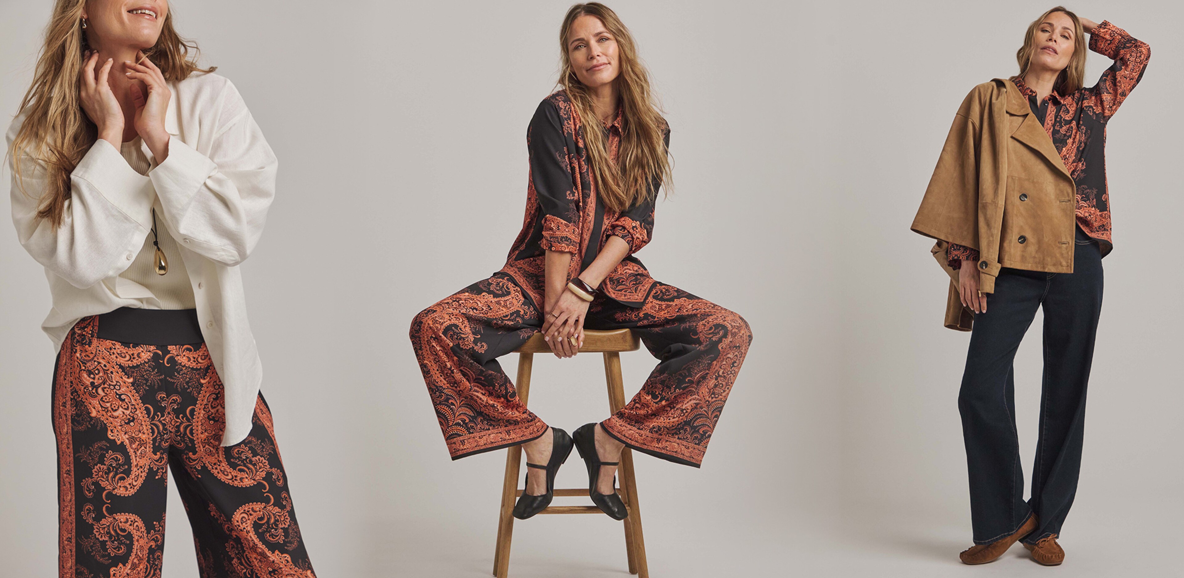 A lady sat on a stool wearing an Anthology Print Shirt and trouser suit.