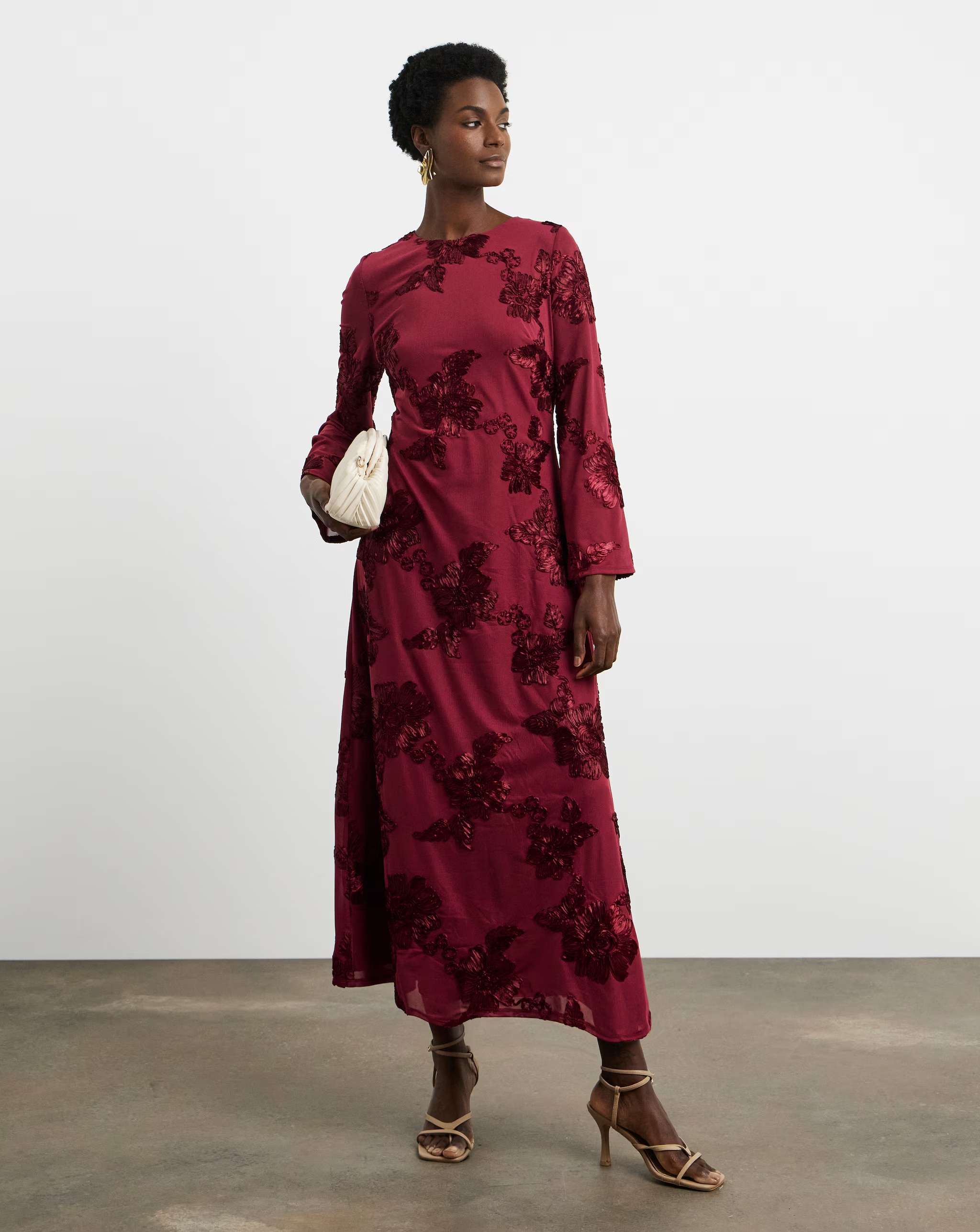 A lady stood up looking to the right wearing a Joanna Hope textured floral dress