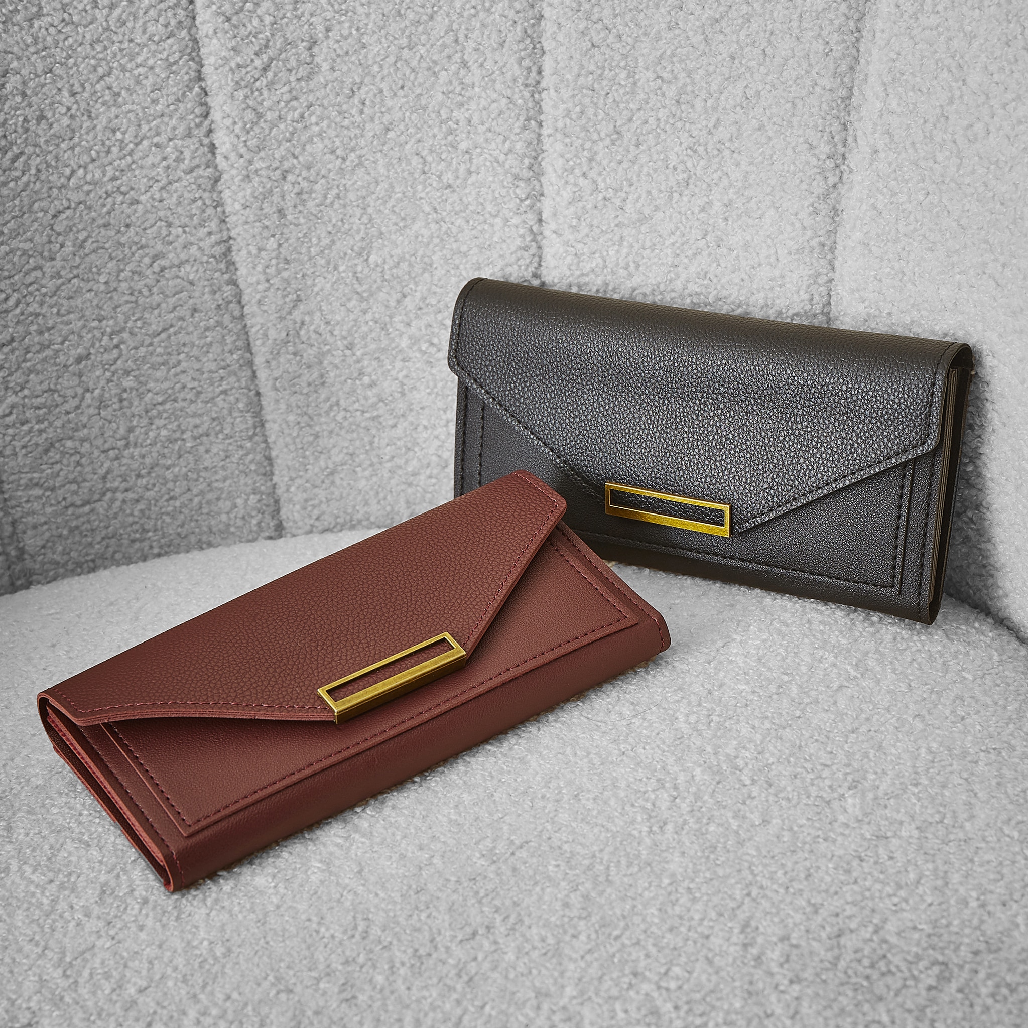 Two hand bags on a grey chair