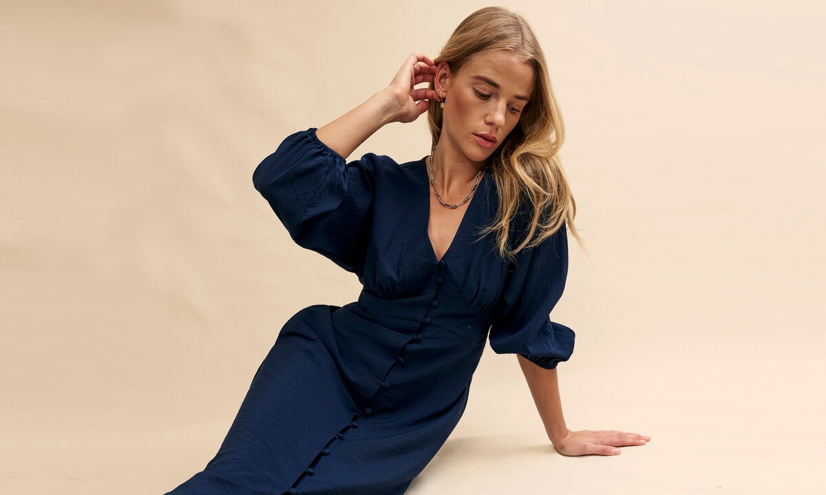 Woman sat wearing a black jumpsuit