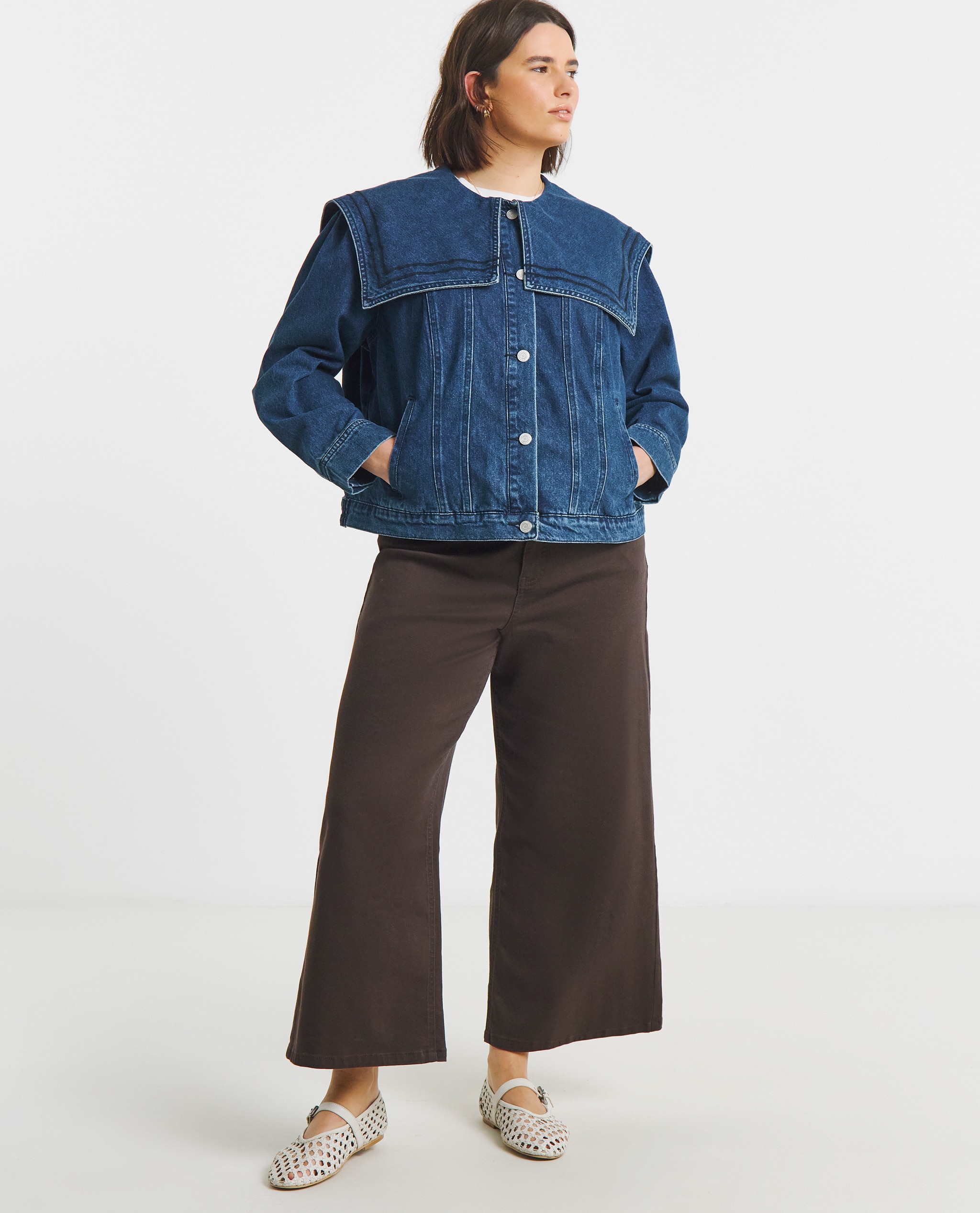 Model is wearing a Simply Be indigo sailor collar denim jacket with chocolate wide leg trousers and a pair of Valerian leather woven Mary Jane ballerina flat shoes.