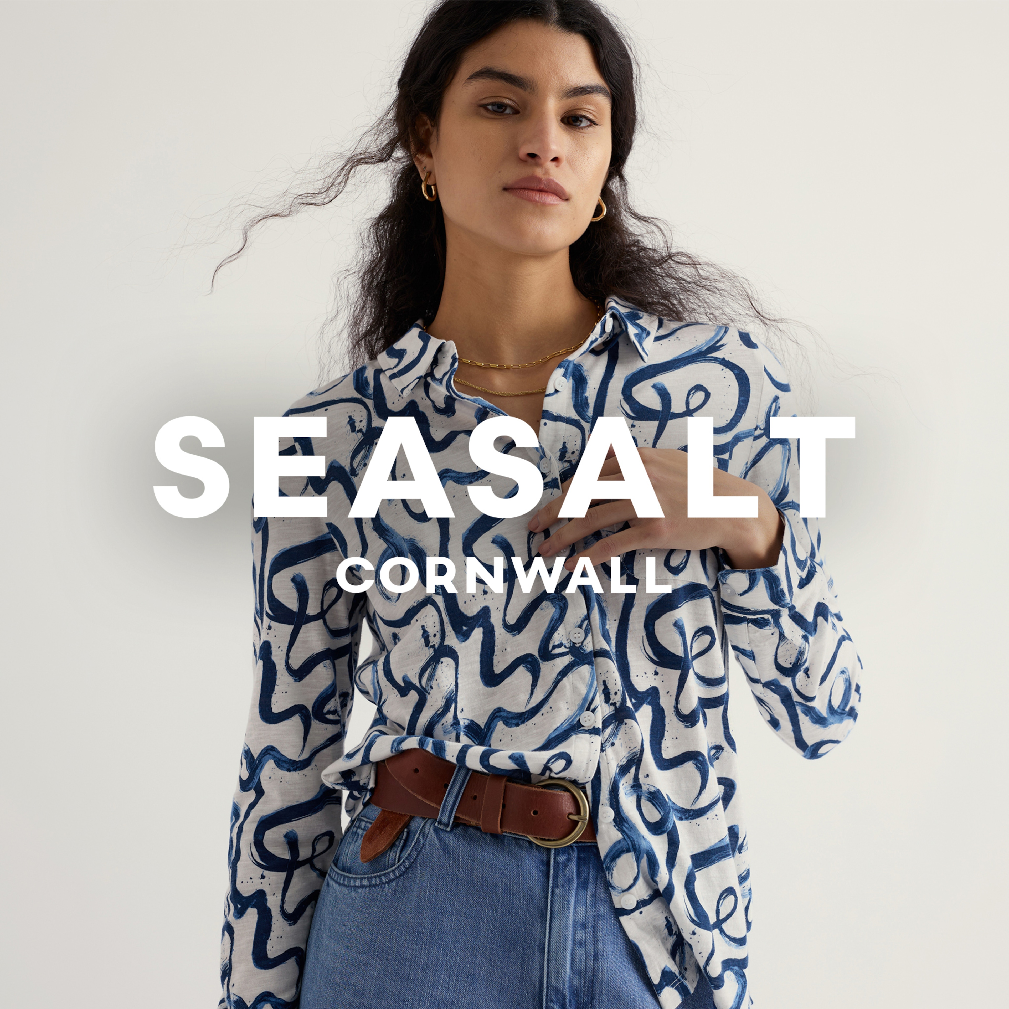 A lady wearing a white and blue printed Seasalt blouse.
