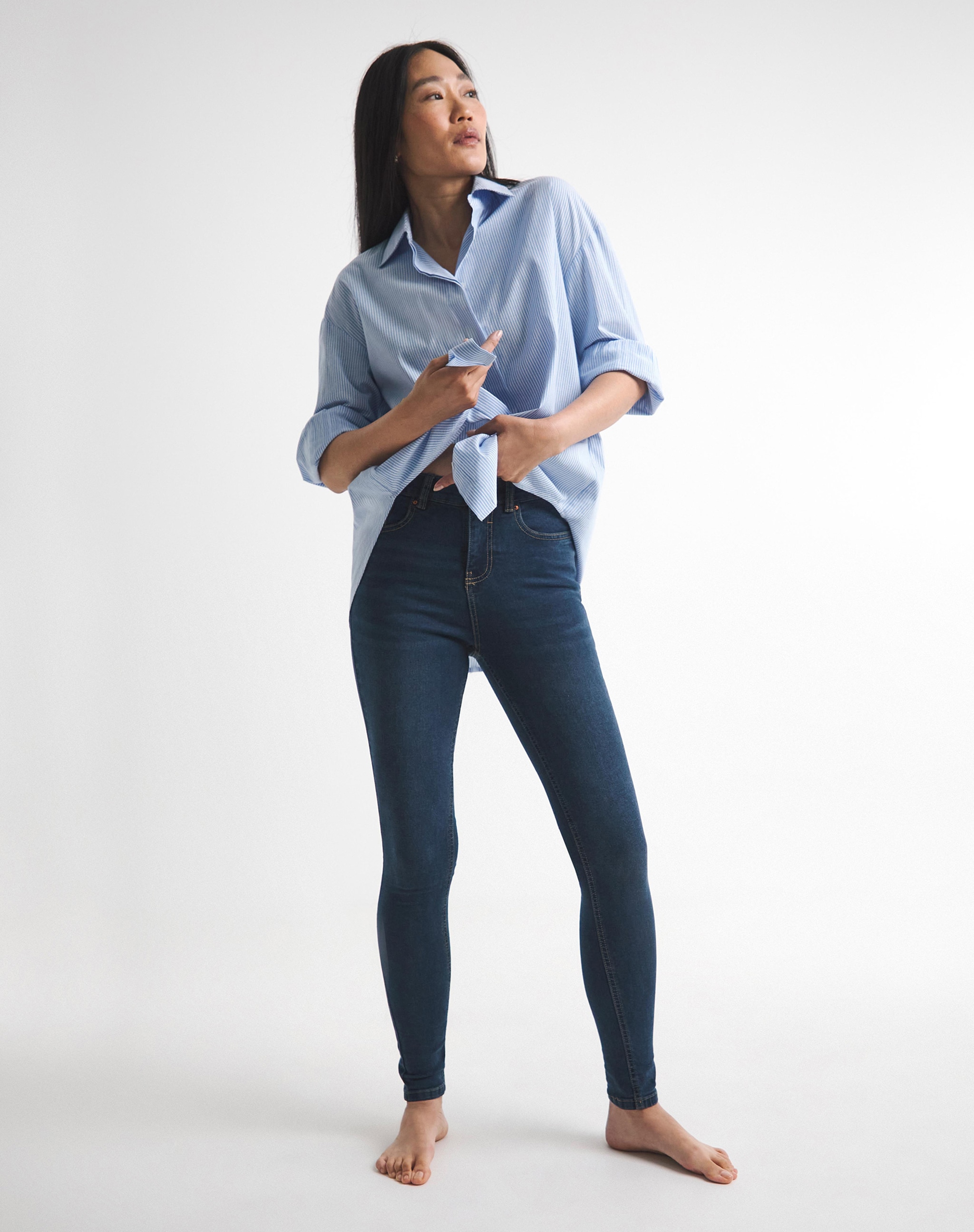Woman wearing a pair of skinny jeans and a denim shirt