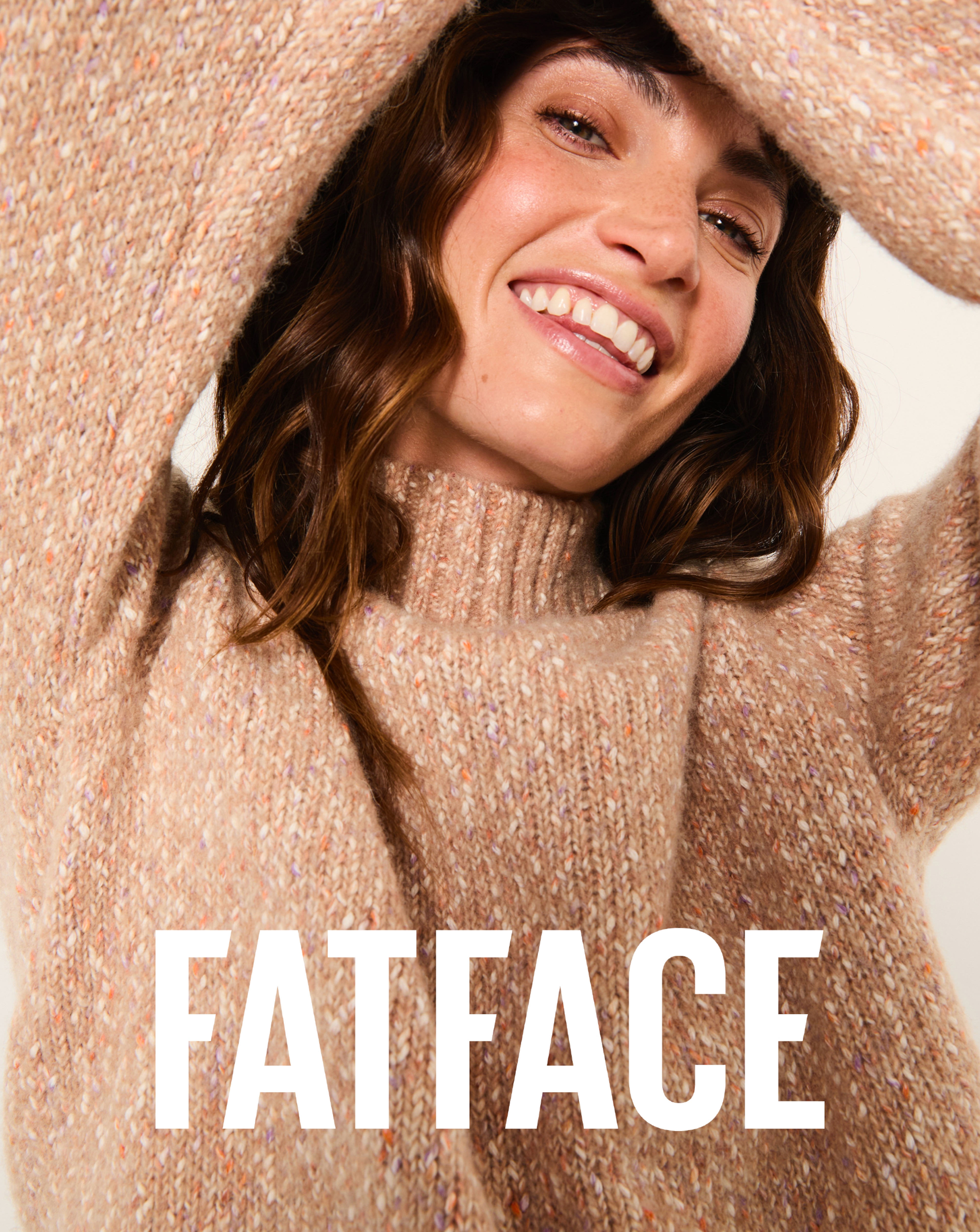 A person wearing a natural coloured funnel neck FatFace jumper.