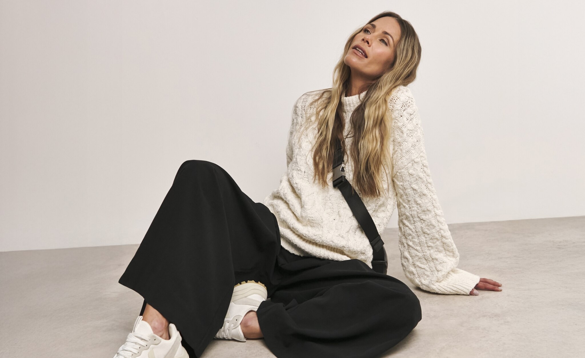 Woman wearing knitted top and black trousers