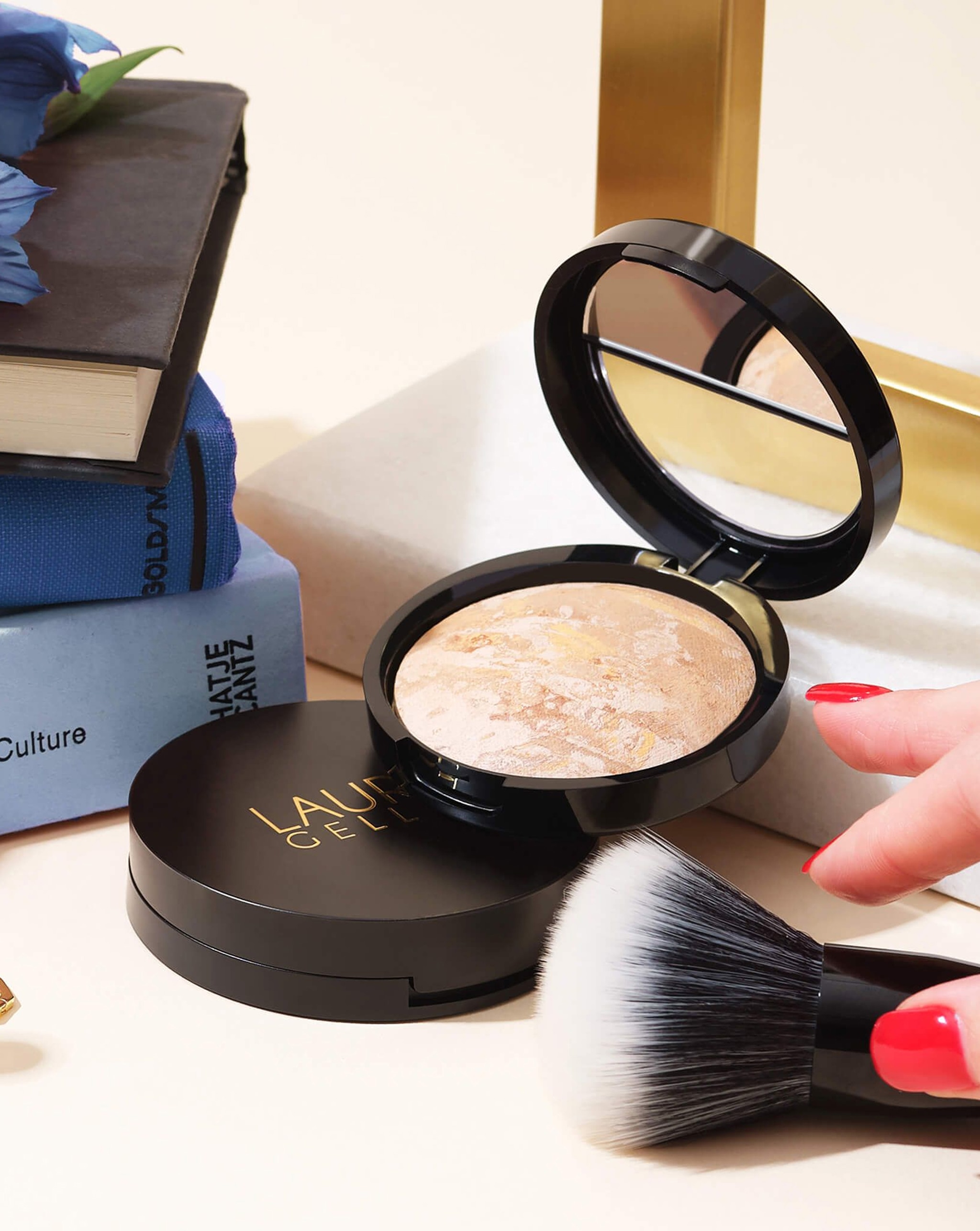 Beauty products opened with a brush and a hand about pick it up.